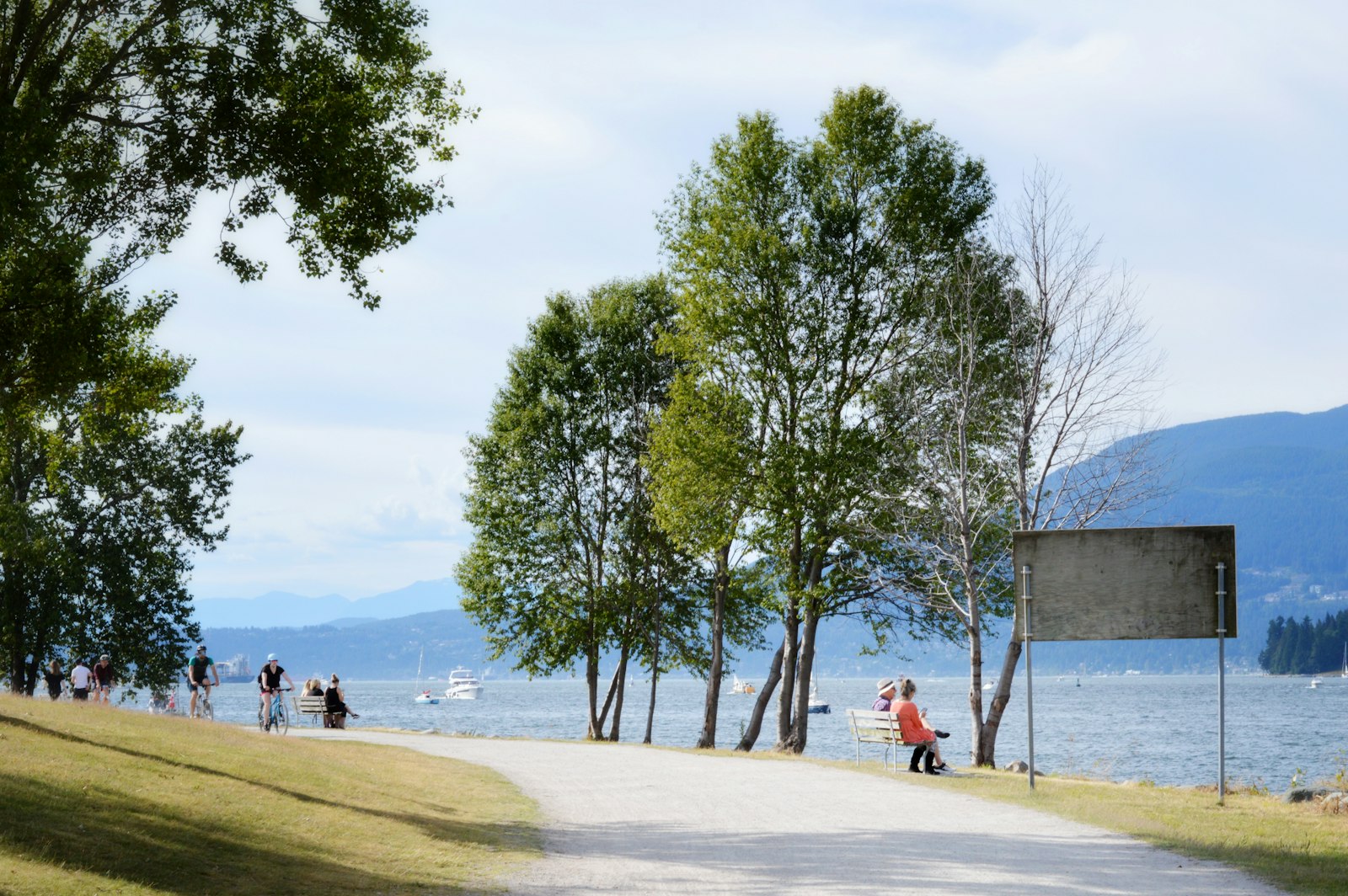 Vancouver seawall — people walking and cycling along the waterfront with mountains in the background